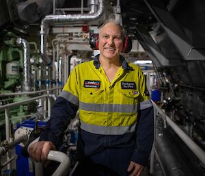 A man in hi vis stands in an engine room