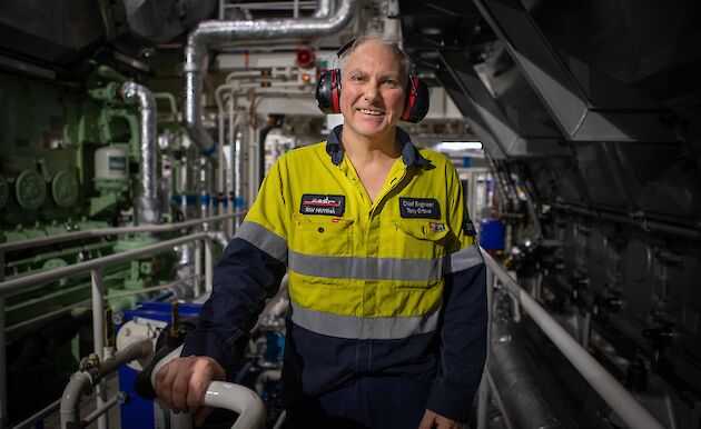 A man in hi vis stands in an engine room