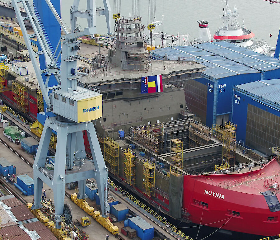 Ship in dry dock undergoing construction.