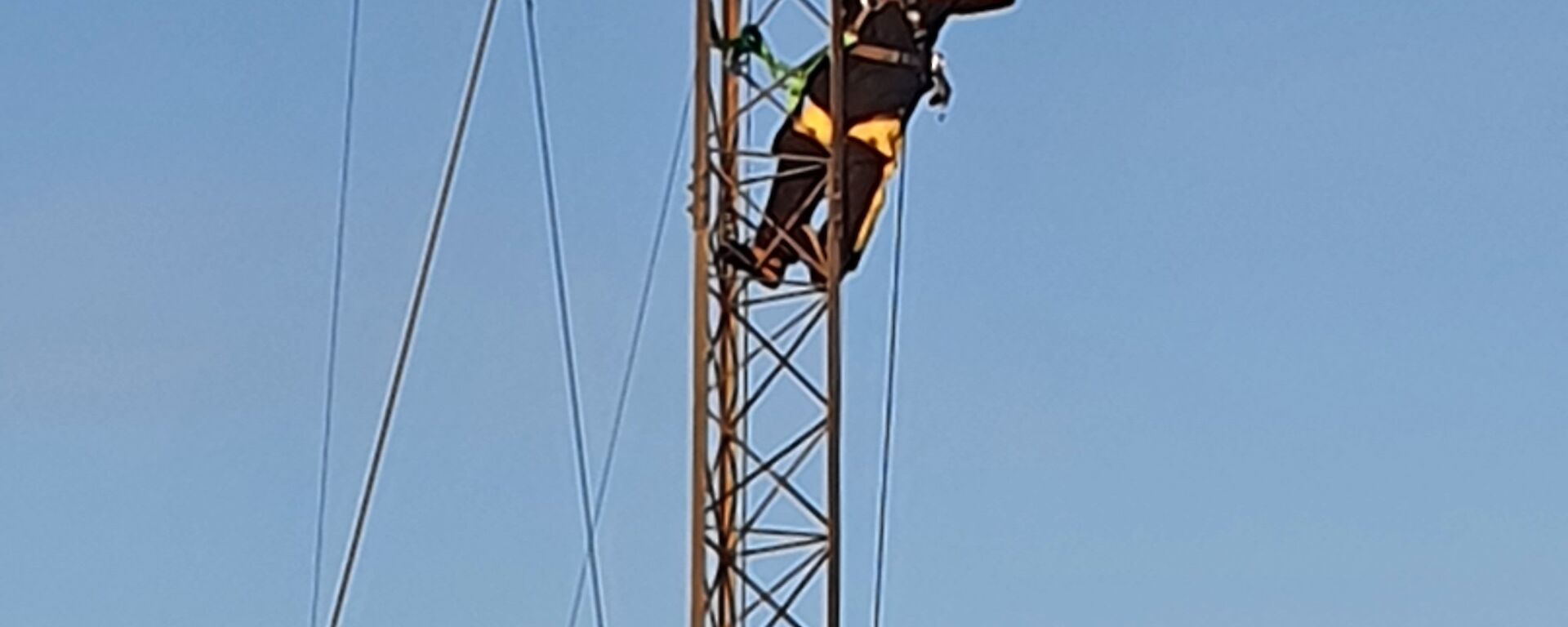 A person half way up an aerial "holds" the moon in their hands for photographic effect