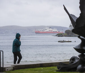 Statue and person in the foreground, framing the RSV Nuyina in the background.