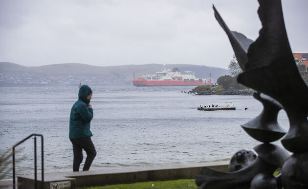 Statue and person in the foreground, framing the RSV Nuyina in the background.