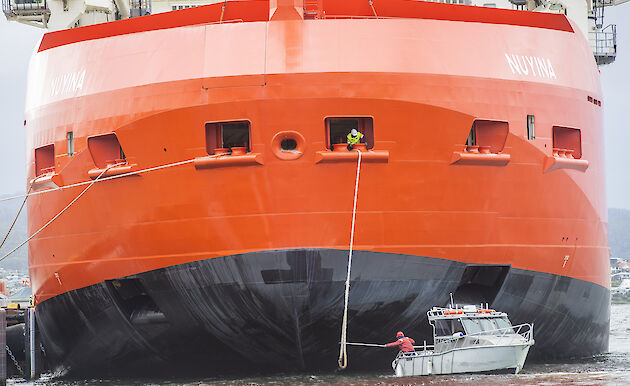 RSV Nuyina at the wharf, with small boat in front