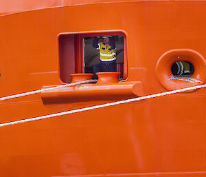Crew member looking out from the RSV Nuyina, near where ropes are tied to the ship