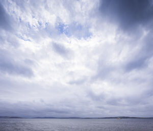 Dramatic scene of clouds over the Derwent with the RSV Nuyina small in the frame