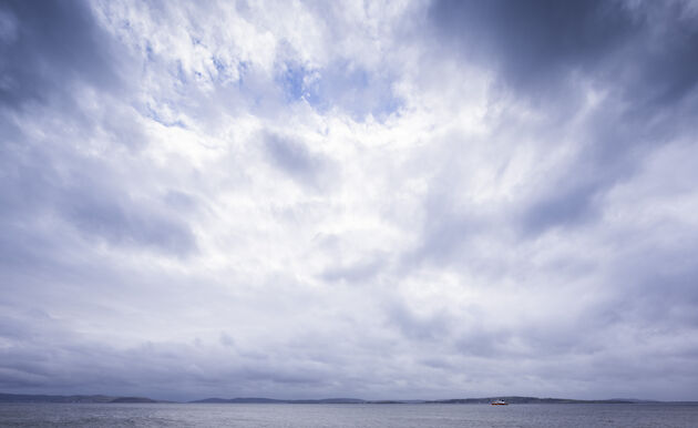 Dramatic scene of clouds over the Derwent with the RSV Nuyina small in the frame