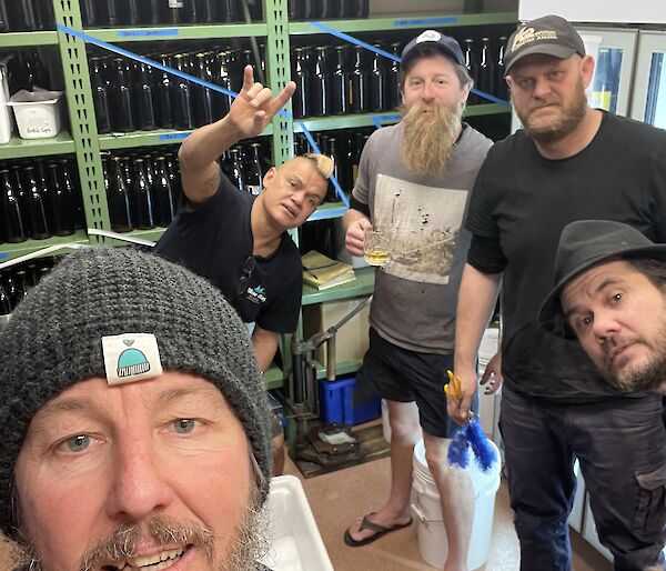 A group of five people gather in the brewing room on station