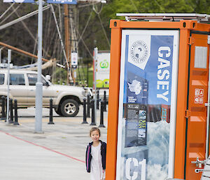 A small child stands next to a mini-container showing Casey station