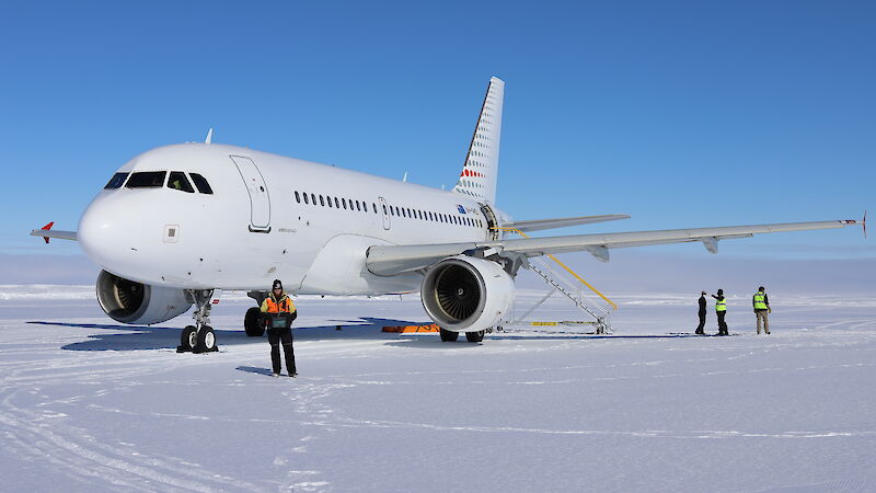 Aeroplane stopped on the runway with expeditioners nearby