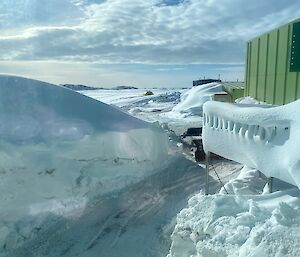 A cluster of shed building surrounded by deep snow and drifts