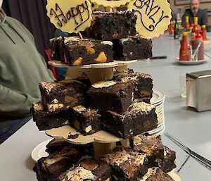 A brownie stack with happy birthday sing on top made of white chocolate.