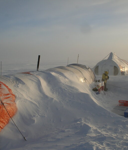 Cylindrical drilling tents covered in snow drift in Antarctica.
