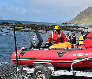 A red dinghy loaded on the back of a trailer