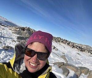 Self taken photo of a woman with lots of penguins in the distance