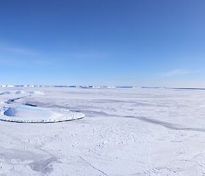 A panorama of the sea ice, nestled between two rocky hills.