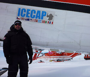 A man stands next to a plane