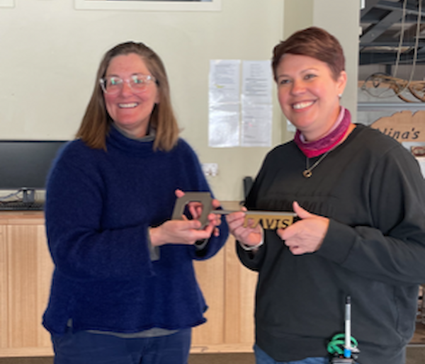 Two woman both holding a large key