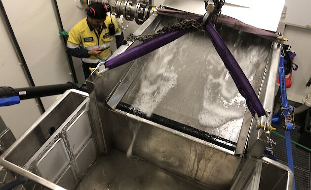 Aerial view of the prototype filter and collection tank, with a stream of water washing across a mesh screen into the tank.