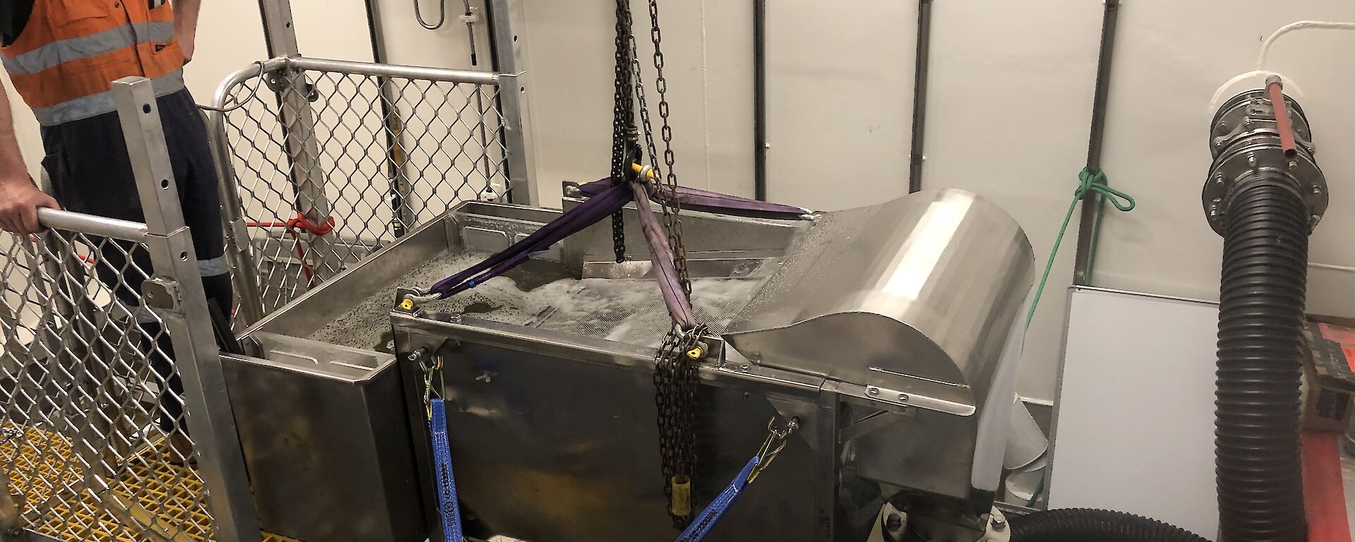 A prototype filter table with water flowing across a steel mesh into a small tank.