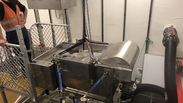 A prototype filter table with water flowing across a steel mesh into a small tank.