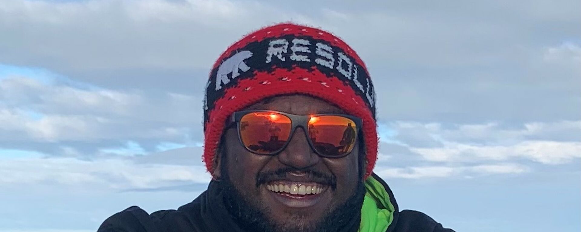 Close up of a man wearing a beanie, sunglases and hoodie