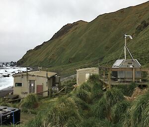 Two small wooden huts with a wind generator close to the shoreline