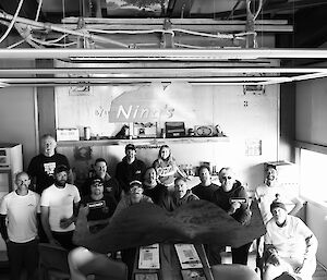 Black and white photo of a group of people with the giant moustache in a bar called Ninas
