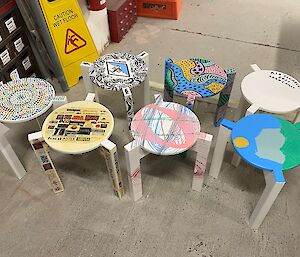 Seven individually painted stools looking colourful and fun
