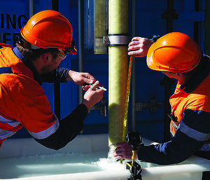 people measuring drill going into ice