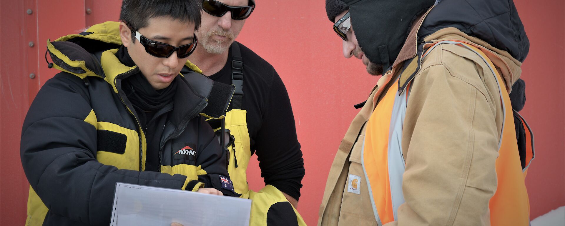 A few members of a search team studying a map of the station