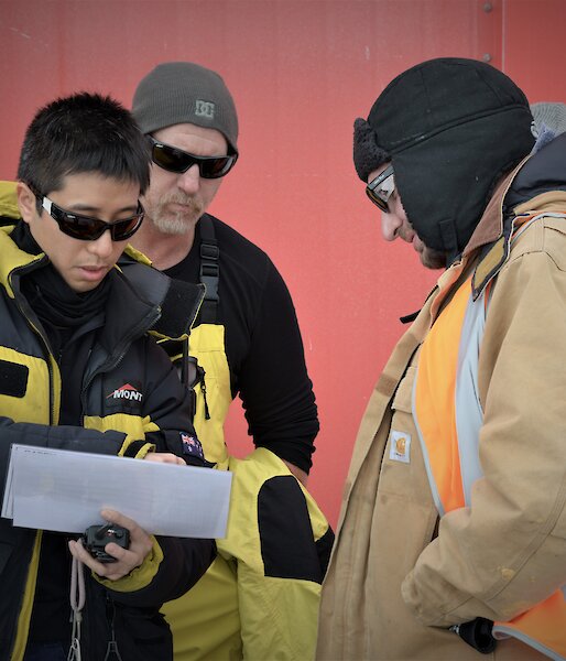 A few members of a search team studying a map of the station