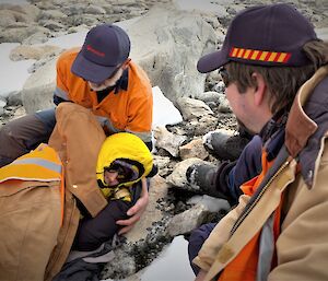 The missing person now found, wrapped in warm clothing and being given first aid by search team members