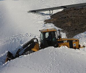 A digger making a road through the snow at Mawson