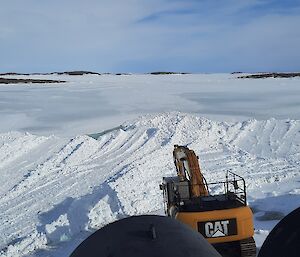 A dozer and digger clearing snow near the lower fuel farm at Mawson