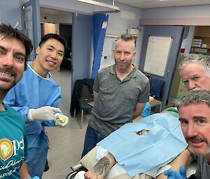 Doctor in gown together with 4 other people in the medical facility