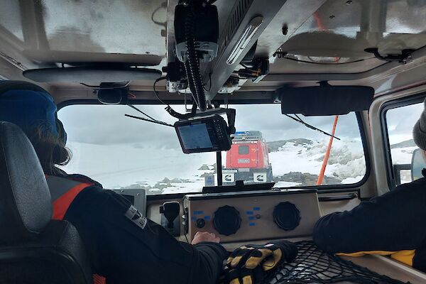 The view from the back seat of a Hägglunds, 2 people in the front seat