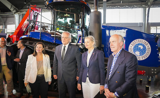 Dignitaries standing in front of an Antarctic traverse tractor.