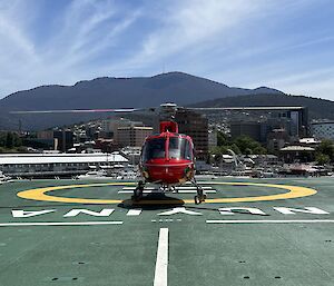 Helicopter on deck of ship with Hobart in background