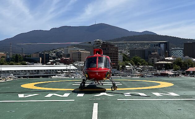 Helicopter on deck of ship with Hobart in background