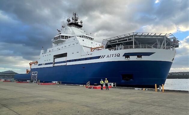 blue and white ship moored at dock