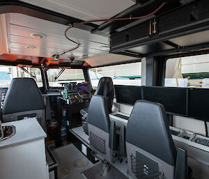 Interior of a small vessel kitted out with seats and screens.