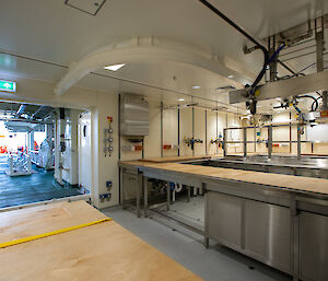 A brightly lit room contains sinks, desks, cabinets and scientific equipment.