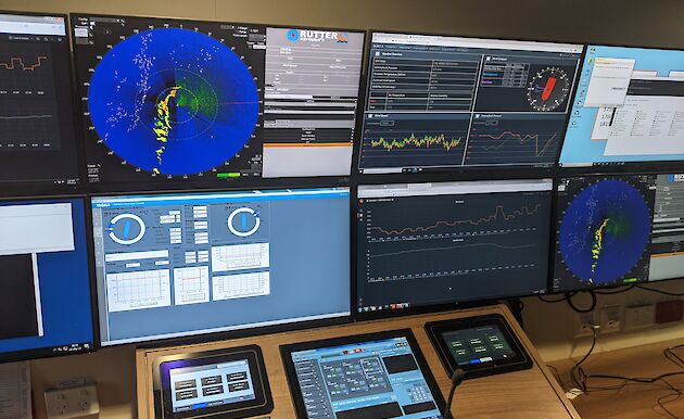 A bank of screens and control panel displaying multiple kinds of data