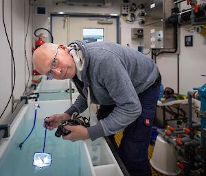 man with small net in aquarium room