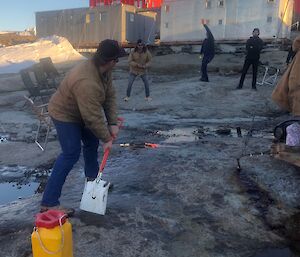 Impromptu game of backyard cricket near the mechanical workshops at Mawson using a shovel as a bat