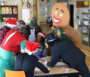 A group of people dressed up in costume huddled around a table