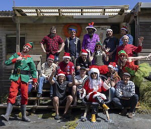 A group photo of the Macquarie Island expeditioners dressed in Christmas garb