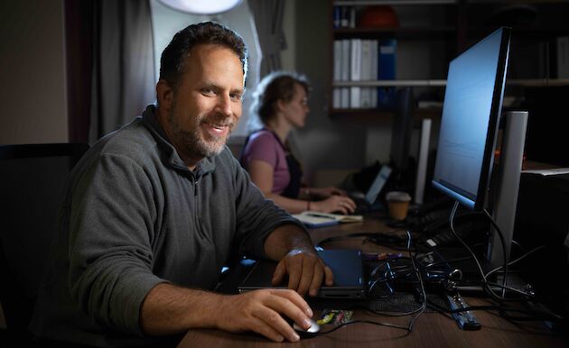 man at computer in room on ship