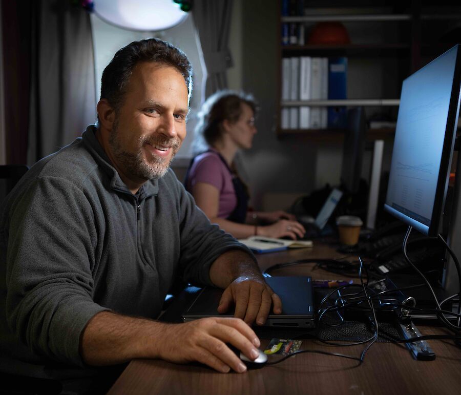 man at computer in room on ship