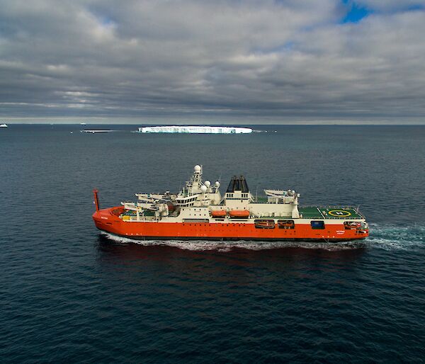 ship at sea with iceberg in background